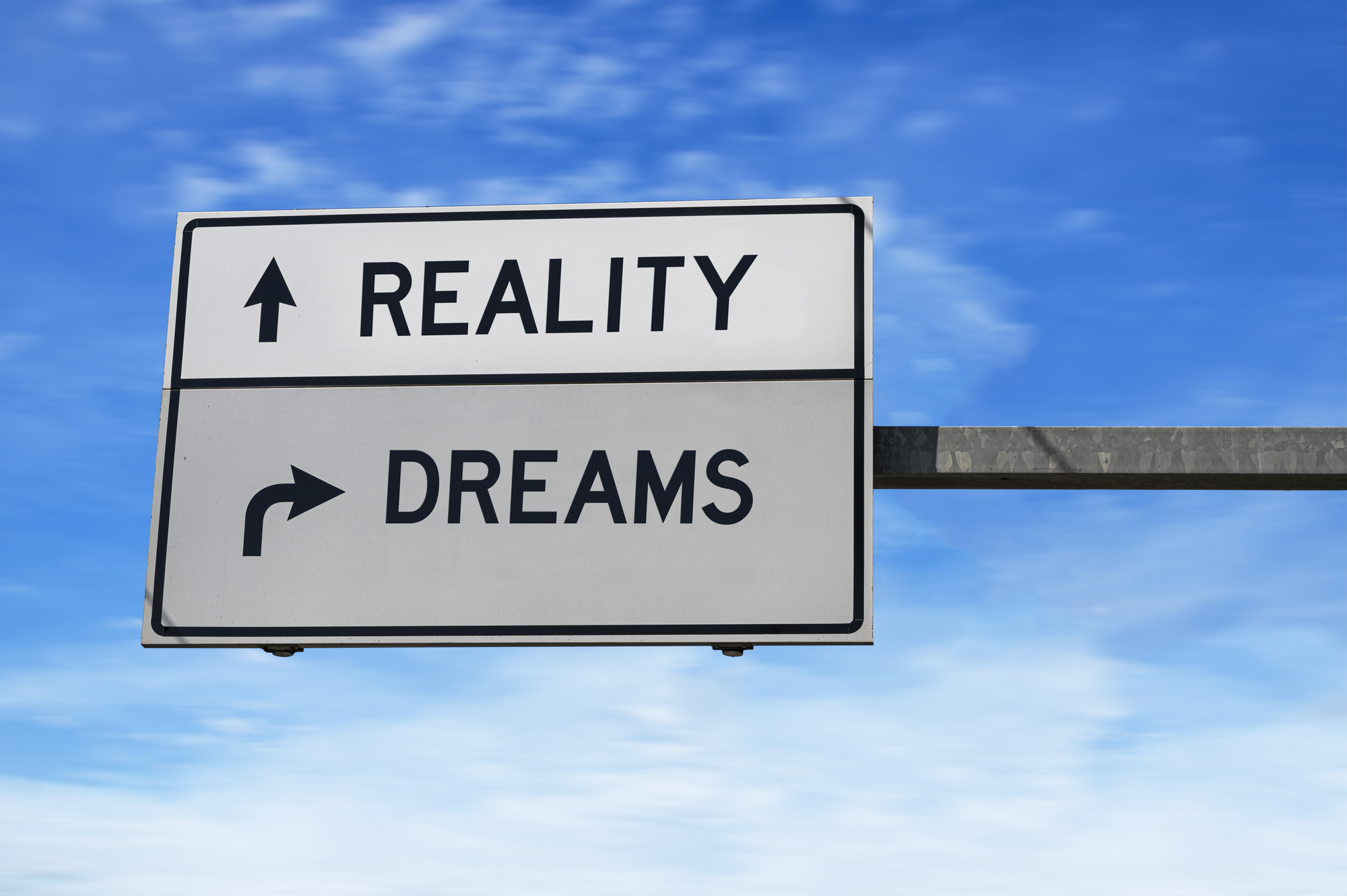 Sign that says reality with an up arrow and dreams with a right arrow 1